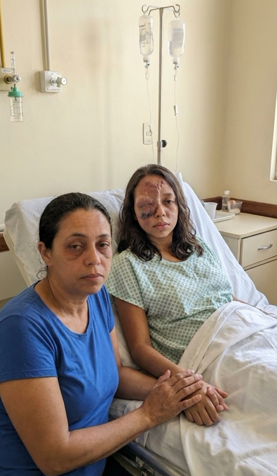 Solange segurando a mão de Ana Júlia no leito do hospital, as duas lado a lado